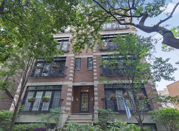 Front view of a multi-story residential building with brick facade and balconies.