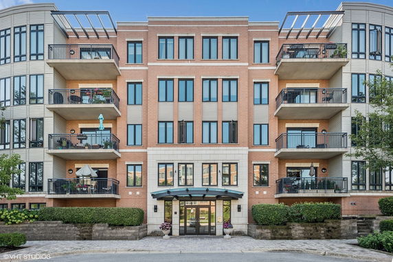 Front view of a multi-story building with balconies and a brick facade.