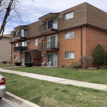 Front view of a multi-story apartment building with balconies.