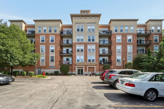 Front view of a multi-story brick apartment building with balconies.