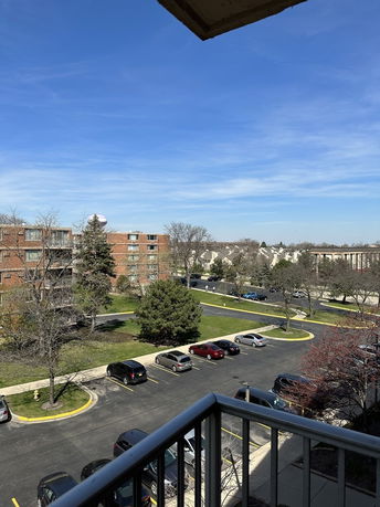View of a parking lot and residential buildings from a balcony.