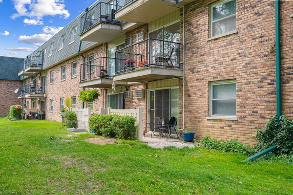 Front view of a multi-story brick apartment building with balconies.