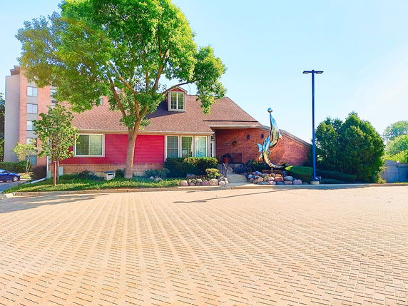 Front view of a house with brick exterior and a sculpture near the entrance.