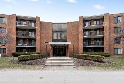 Front view of a multi-story apartment building with balconies.