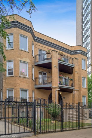 Front view of a multi-story brick building with balconies.