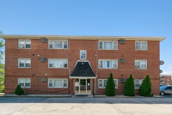 Front view of a three-story brick apartment building.