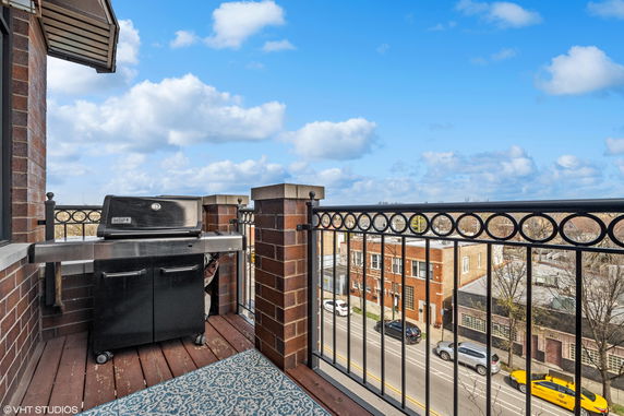 Rooftop area with a barbecue grill and a view of the cityscape.
