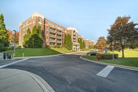 Front view of a multi-story brick residential building with balconies.
