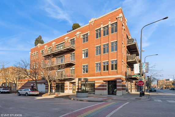 Front view of a multi-story red brick building with balconies.