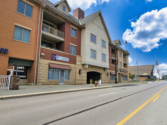 Front view of a multi-story building with mixed brick and stone exterior.