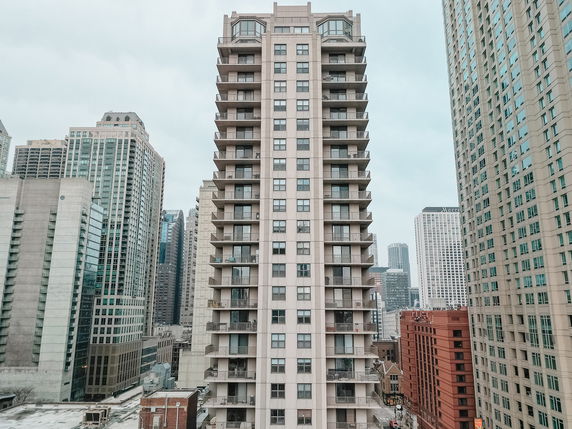 Front view of a multi-story residential building in a cityscape.