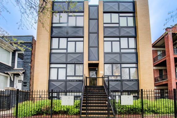 Front view of a multi-story building with modern design and external staircase.