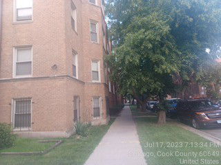 Side view of a multi-story brick building with adjacent sidewalk