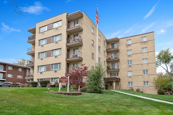 Front view of a multi-story condominium building with balconies.