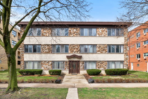 Front view of a multi-story building with brick and stone exterior.
