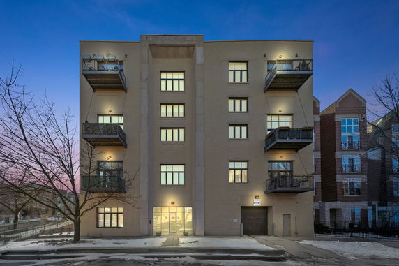 Front view of a multi-story apartment building with outdoor balconies.
