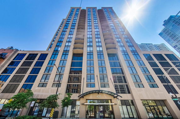 Front view of a tall building with multiple stories and glass windows.