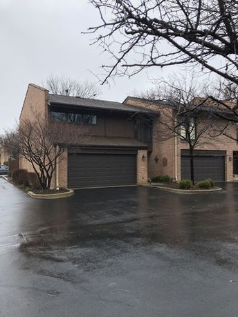 Front view of a two-story brick house with an attached double garage.
