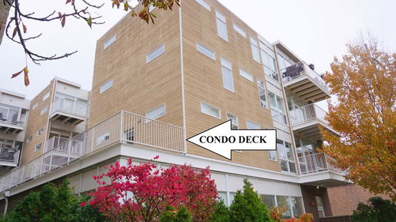 Front view of a multistory condominium building with balconies.