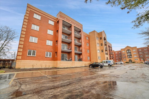 Front view of a multi-story apartment building with balconies.