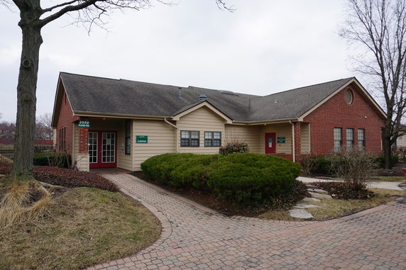 Front view of a clubhouse with a brick and siding exterior.