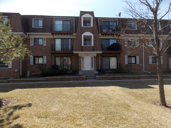Front view of a multi-story brick building with balconies.
