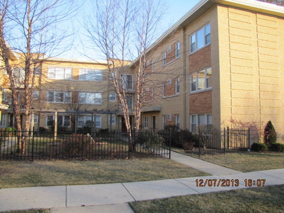 Front view of a three-story brick apartment building.