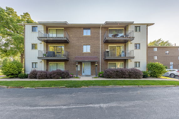 Front view of a three-story apartment building with balconies.
