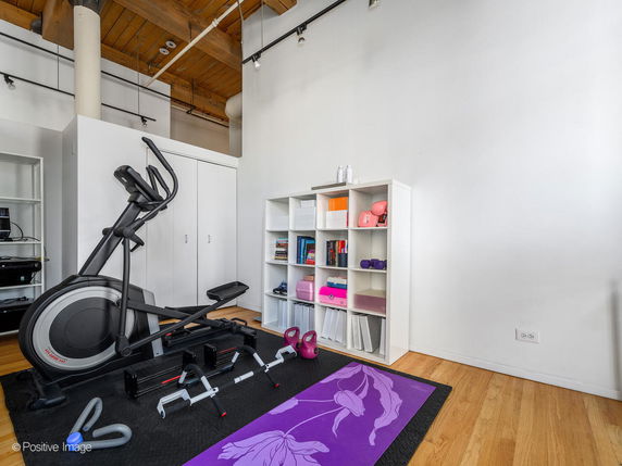 Indoor gym area with exercise equipment and storage shelves.