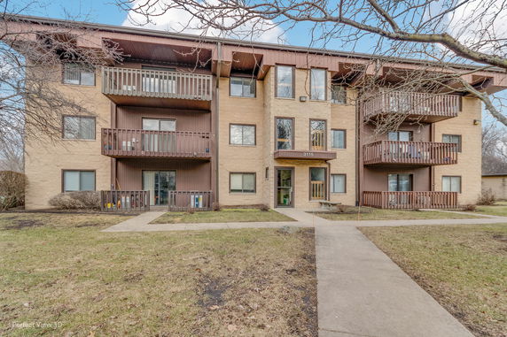 Front view of a multi-story apartment building with balconies.