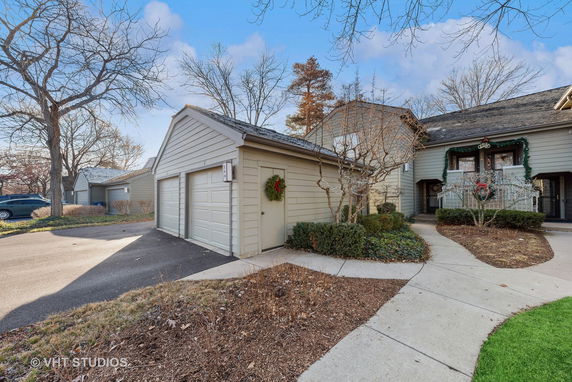 Front view of a house with adjoining garage and landscaped walkway.