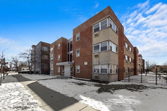 Front view of a multi-story brick apartment building.