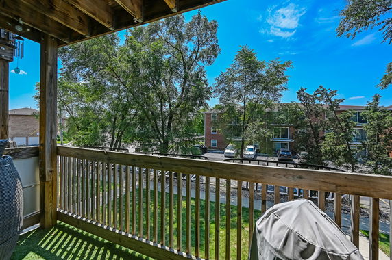 View from a balcony overlooking surrounding buildings and trees.
