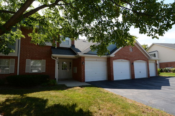Front view of a two-story house with a triple garage and brick exterior.