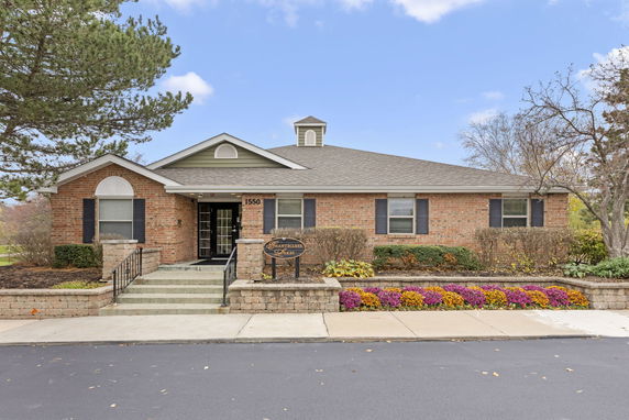 Front view of a single-story brick building with a sloped roof and entrance steps.