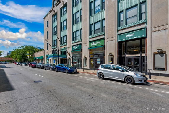 Front view of a multi-story commercial building with shops on the ground floor.