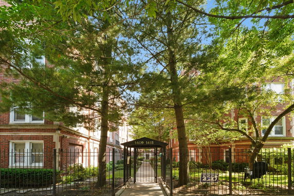 Front view of a red brick residential building with gated entrance.