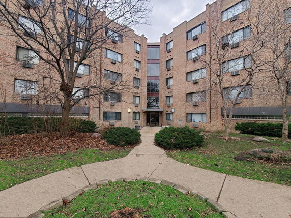 Front view of a multi-story brick apartment building.
