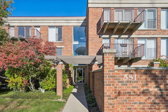 Front view of a brick apartment building with balconies.