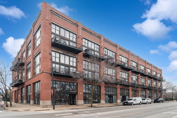 Front view of a multi-story brick building with balconies.