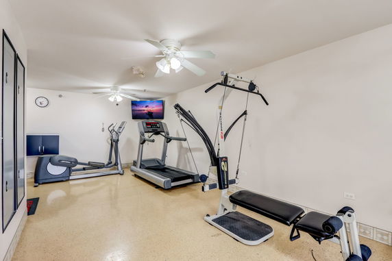 Home gym area with exercise equipment including a treadmill and weight machine.