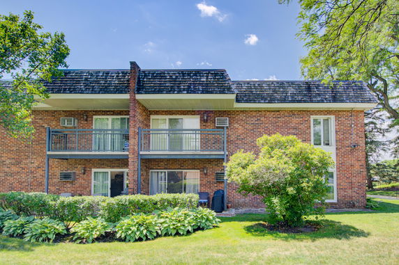 Front view of a two-story brick house with balconies.