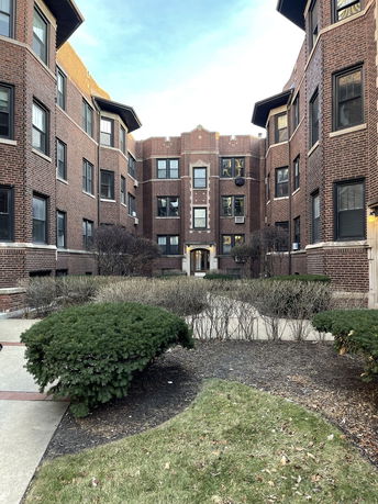 Front view of a brick apartment building with multiple stories.