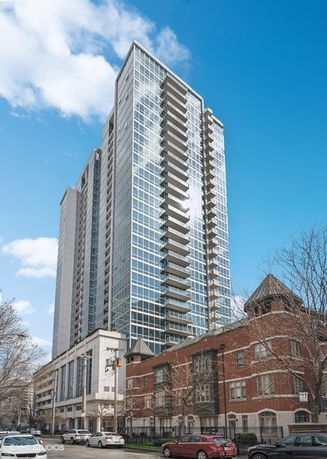 Front view of a tall, modern high-rise building with glass facade.