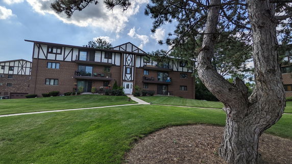 Front view of a multi-story residential building with brick and white facade.