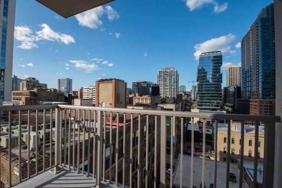 View from a balcony overlooking a cityscape with several tall buildings.