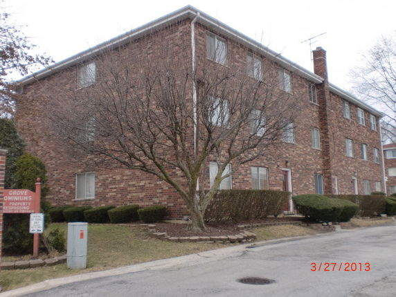 Front view of a three-story brick condominium building.