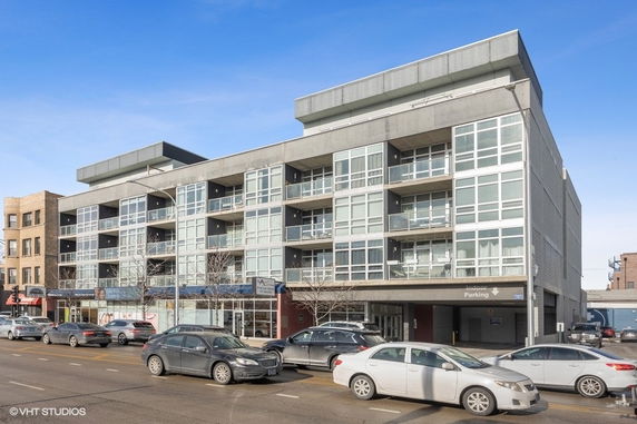 Front view of a multi-story modern building with large windows and balconies.