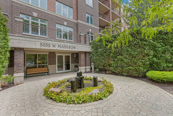 Front view of a multi-story building with brick facade and entrance walkway.