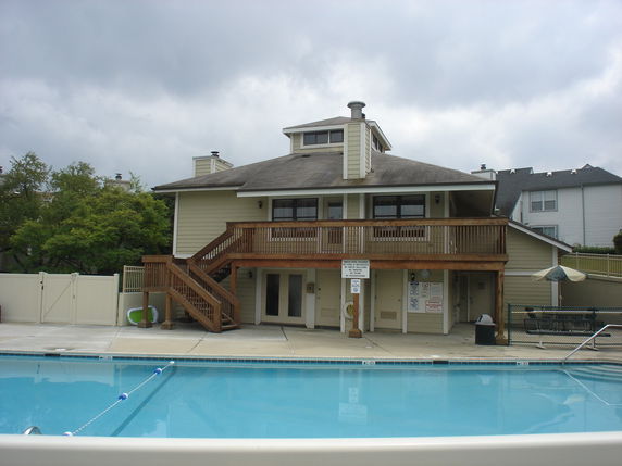 Front view of a building with a swimming pool in front.